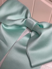 a close up of a mint green satin bow